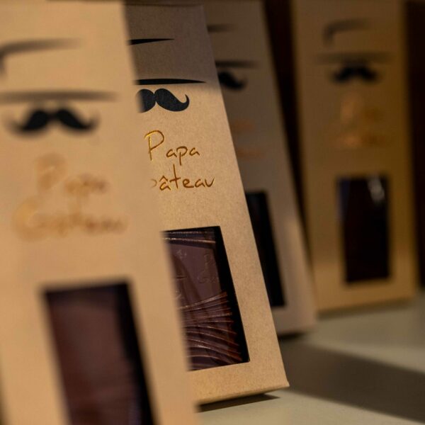 Tablettes de chocolat Papa Gateau Étiquettes de produits chocolatés Papa Gâteau exposées sur un présentoir.