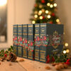 calendrier-avant-noel-livre Calendrier de l’Avent en forme de livre, garni de chocolats artisanaux Papa Gâteau, présenté devant un sapin de Noël dans une ambiance festive.